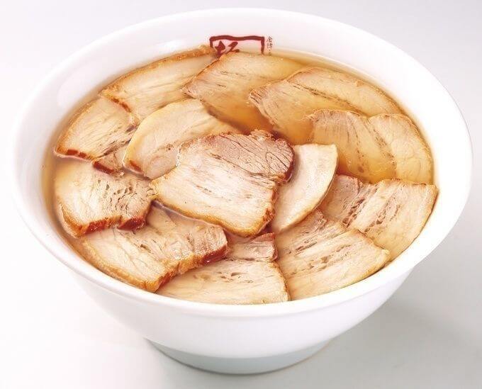 The noddles are hiding within a huge layer of roast pork.