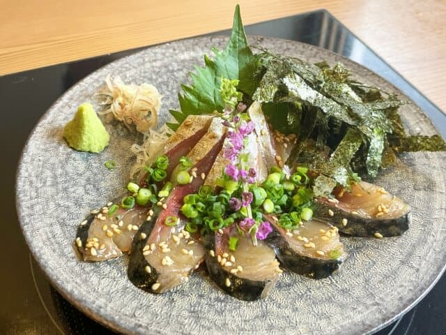 Goma Saba with wasabi and other green leaves as garnish