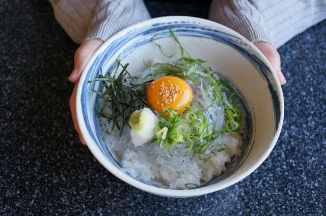 有人拿著一碗生鯊魚仔蓋飯