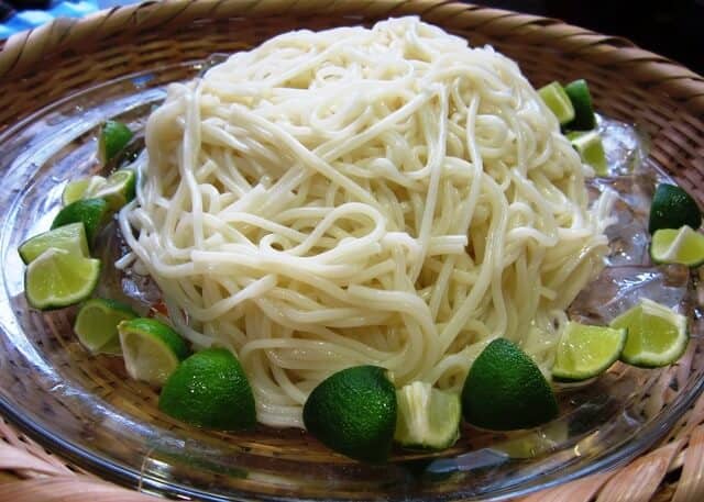 Handa somen with many cut limes around it on a glass plate