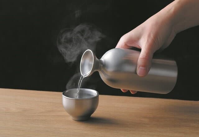 Hot sake on stainless pot and tea cup